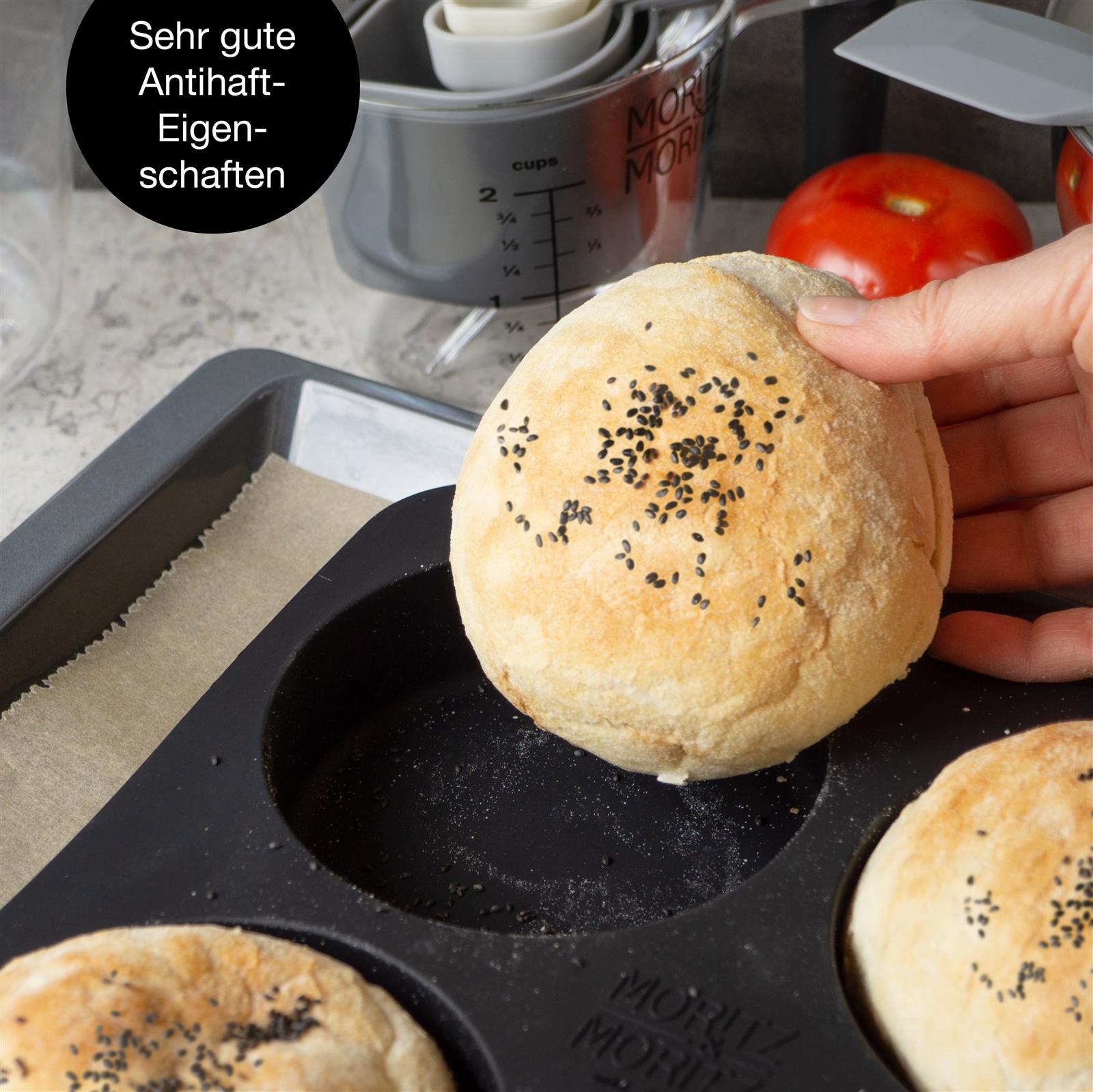 Backform in Rot, Sechs goldbraun gebackene Burgerbrötchen mit glatter Oberfläche liegen in einer schwarzen