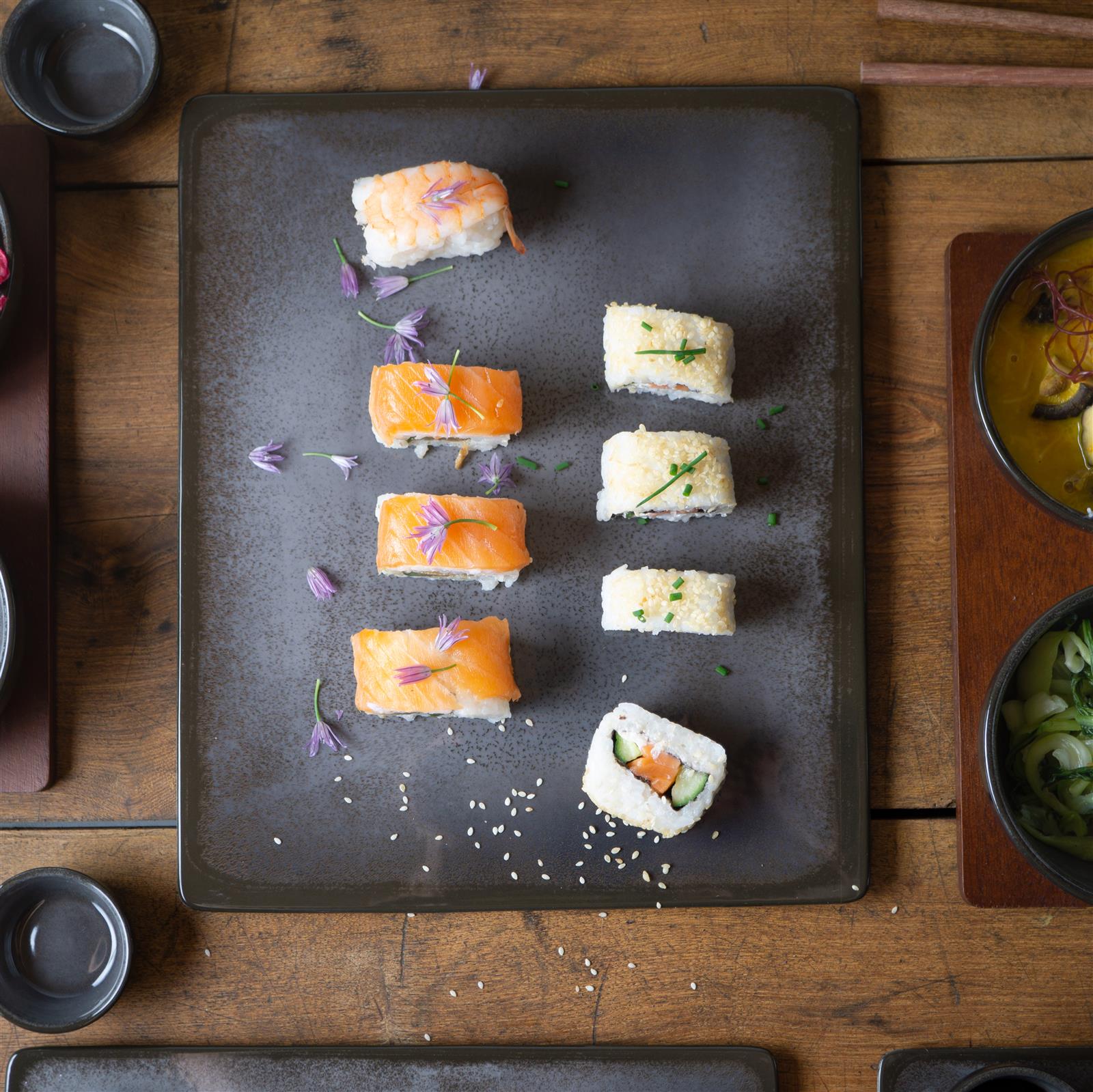 Sushi-Geschirr in Grau, 29-teiliges Sushi-Set in Grau auf einem gedeckten Tisch, bestehend aus rechteckigen Sushi-Tellern