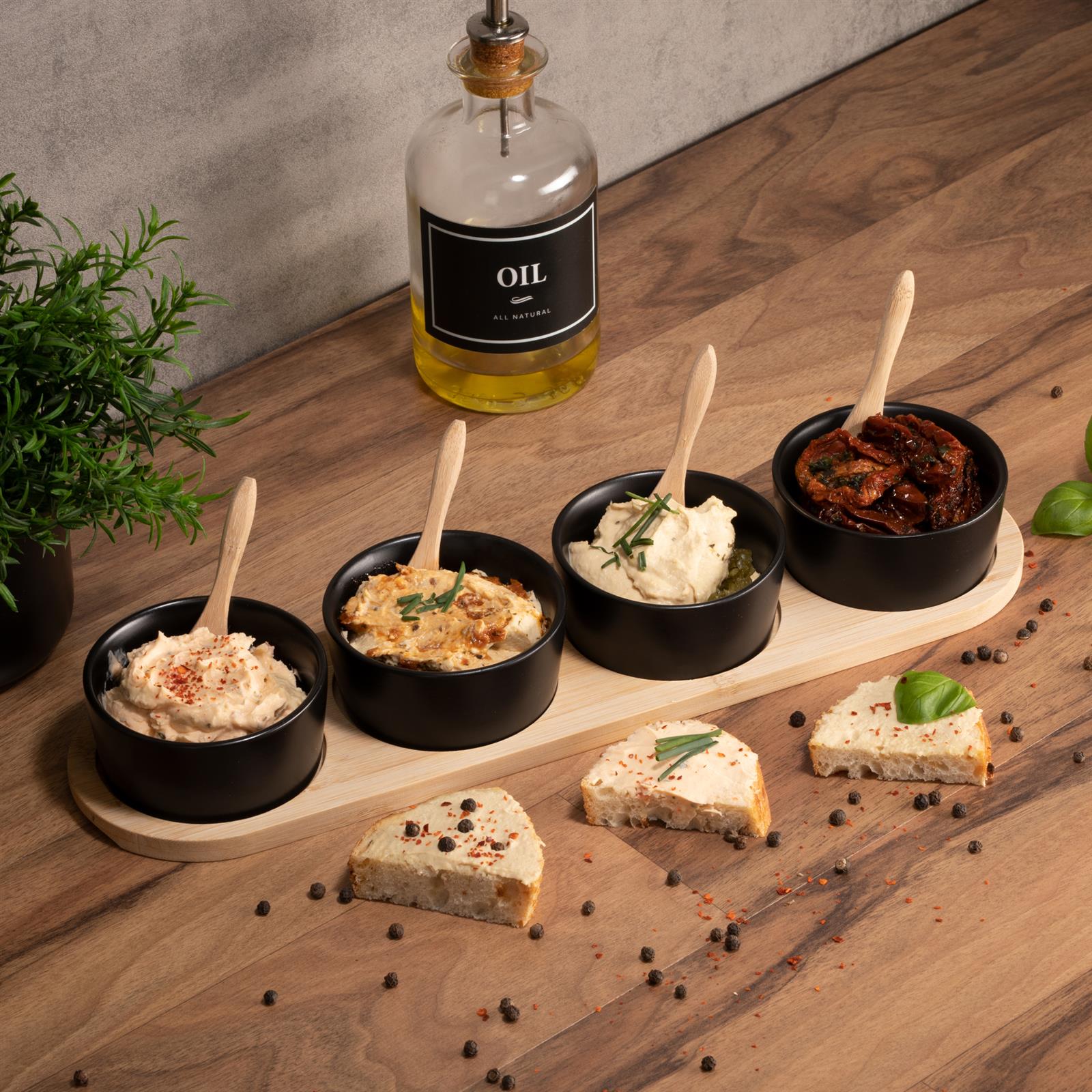 4 schwarze Keramikschalen mit Bambus-Träger – stilvolles Geschirr-Set für jede Küche Vier schwarze Keramikschalen in unterschiedlicher Größe stehen gestapelt in einem Bambusträger mit Griff auf einem hellen Untergrund.