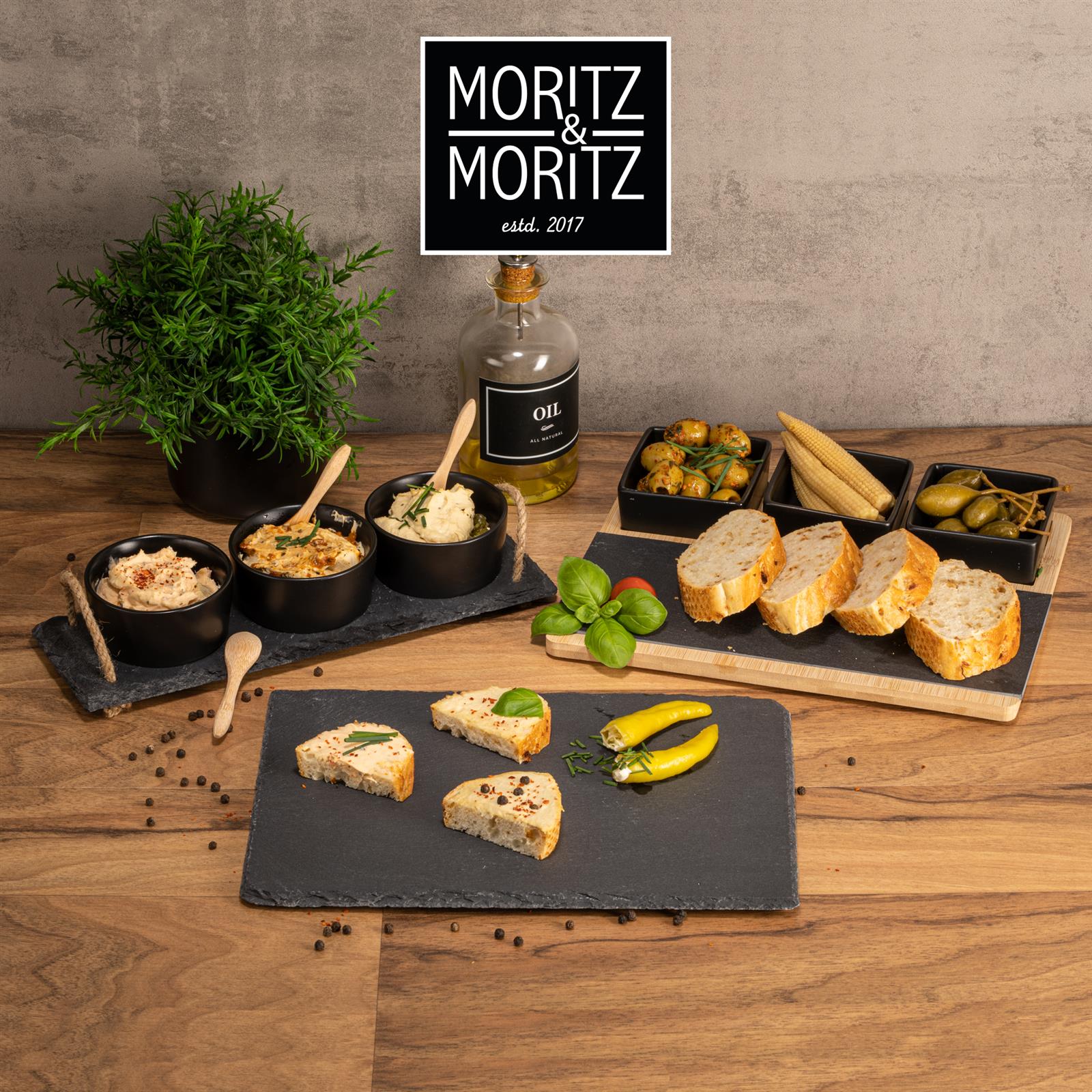 Bambusbrett mit eingebetteter Schieferplatte und drei schwarzen Schalen