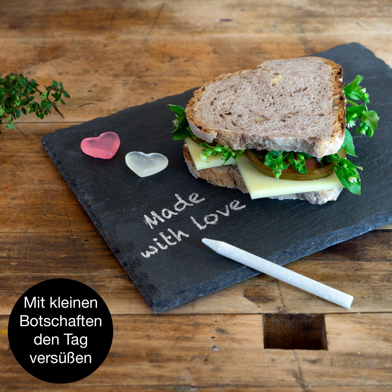 Servierplatte in Rosa, Nahaufnahme eines geschnittenen Roastbeefs auf dunkler Schieferplatte, garniert mit frischem Thymian
