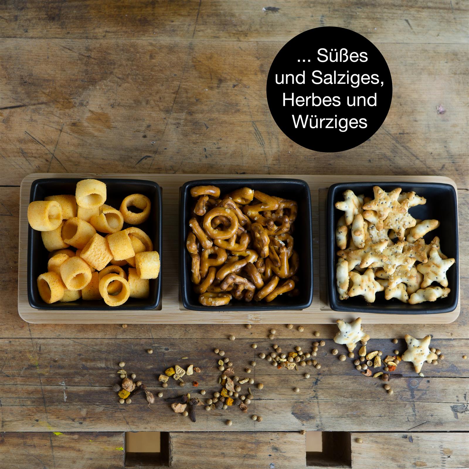 Schieferfarbene Gewürzschale mit fein gemahlenem, gelb-orangefarbenem Curry auf dunkler Steinplatte