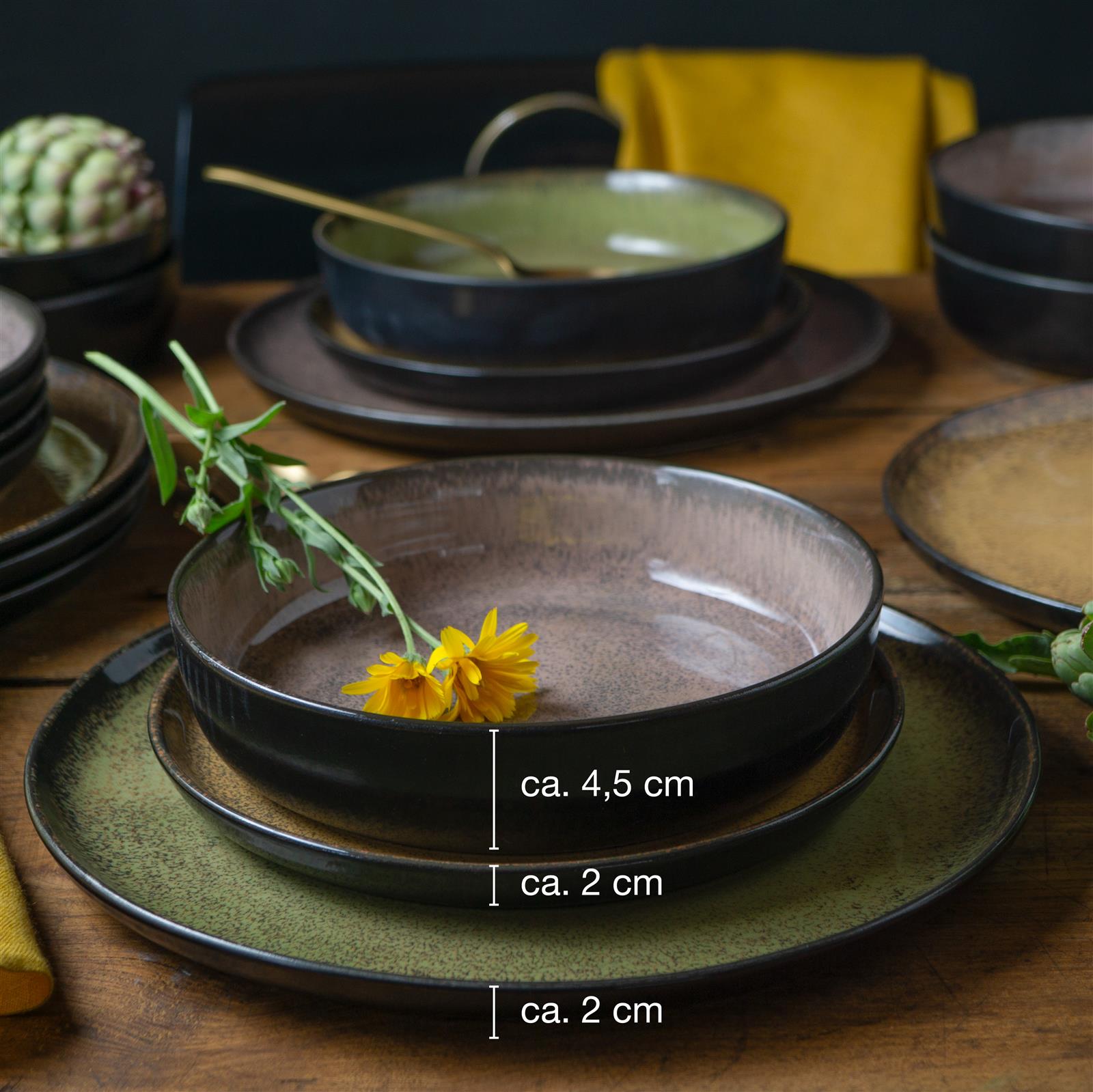 Geschirrset im Vintage-Stil bestehend aus Tellern, Schüsseln und Tassen in Beige- und Grautönen mit dezentem, unregelmäßigem Randdesign, auf einem hellen Untergrund arrangiert.