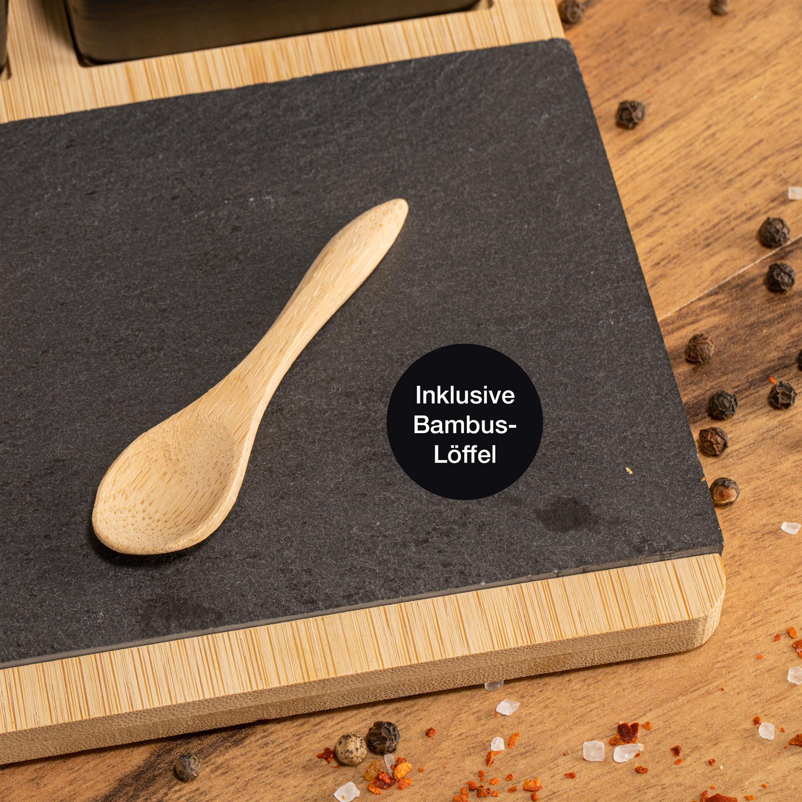 Bambusbrett mit Schieferplatte und drei schwarzen Schalen, Tapas oder Käseplatten. Design für Küche und Dinnerpartys