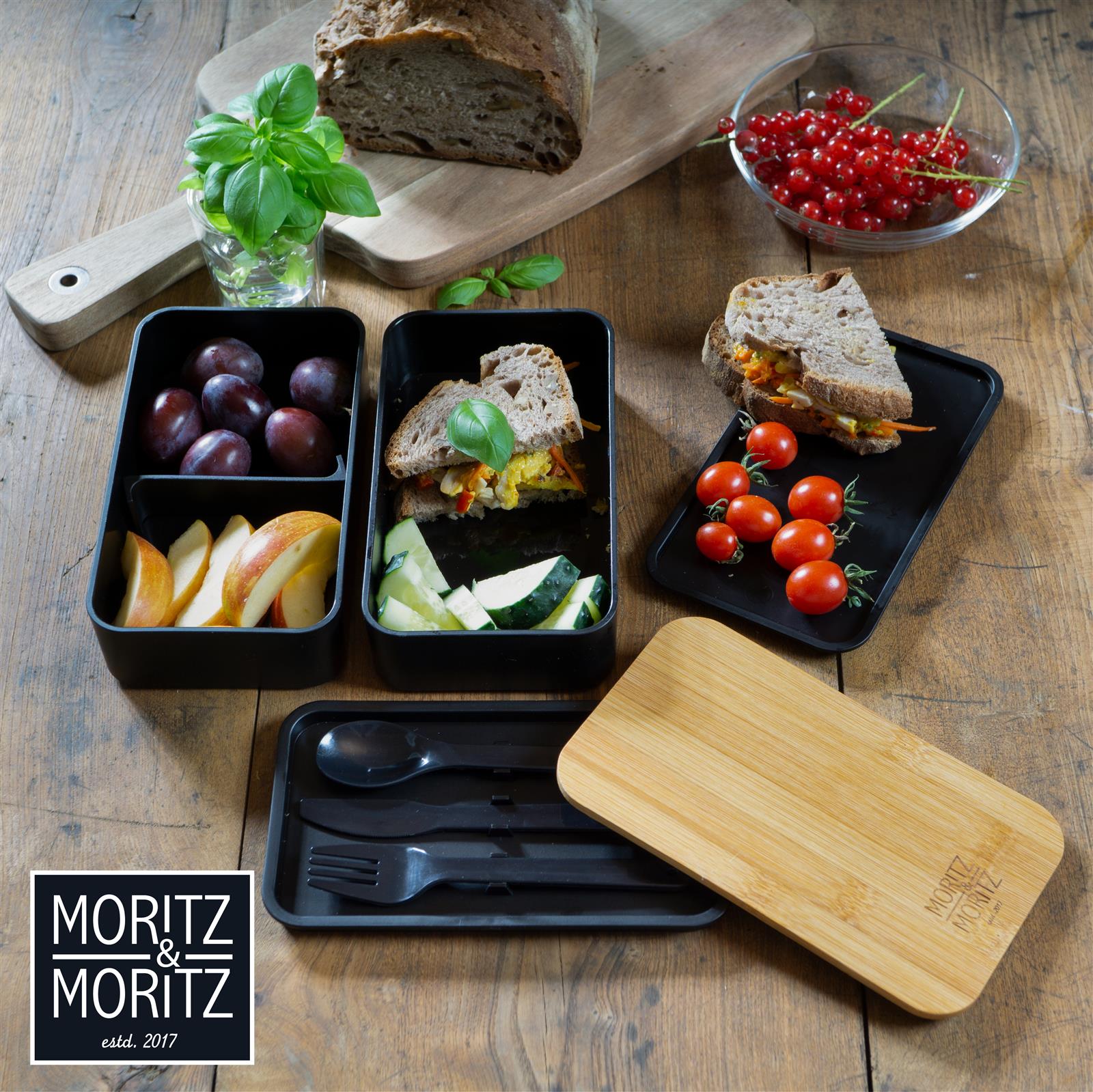 Bento Box mit ausgewogener, gesunder Auswahl an Sushi, Gemüse und Beilagen auf heller, Unterlage bei Tageslicht