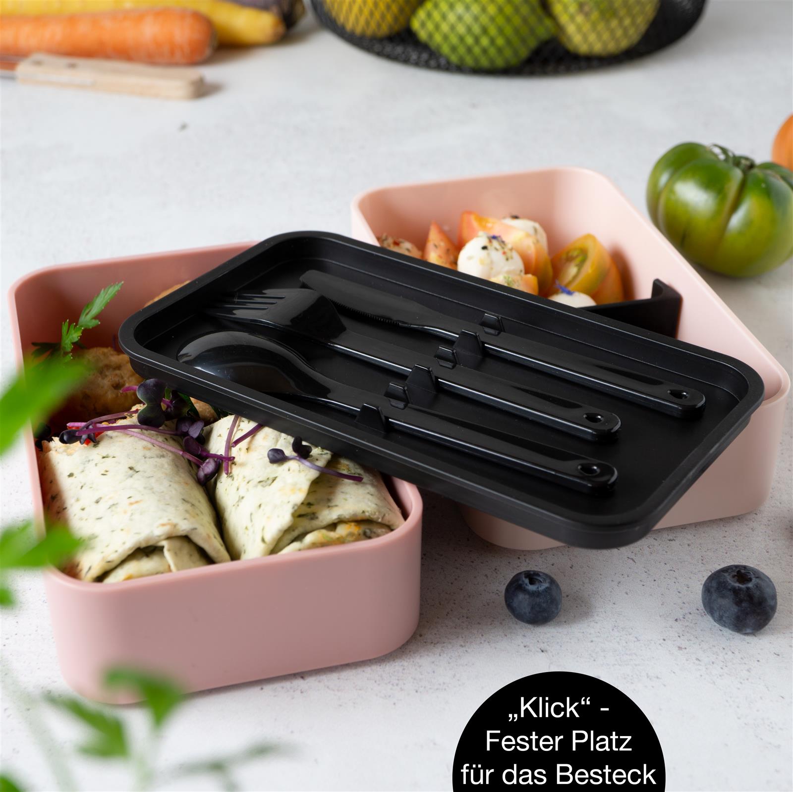 Bentobox in Rosa mit mehreren Fächern für eine Mahlzeit, sorgfältig arrangierte Speisen und Design