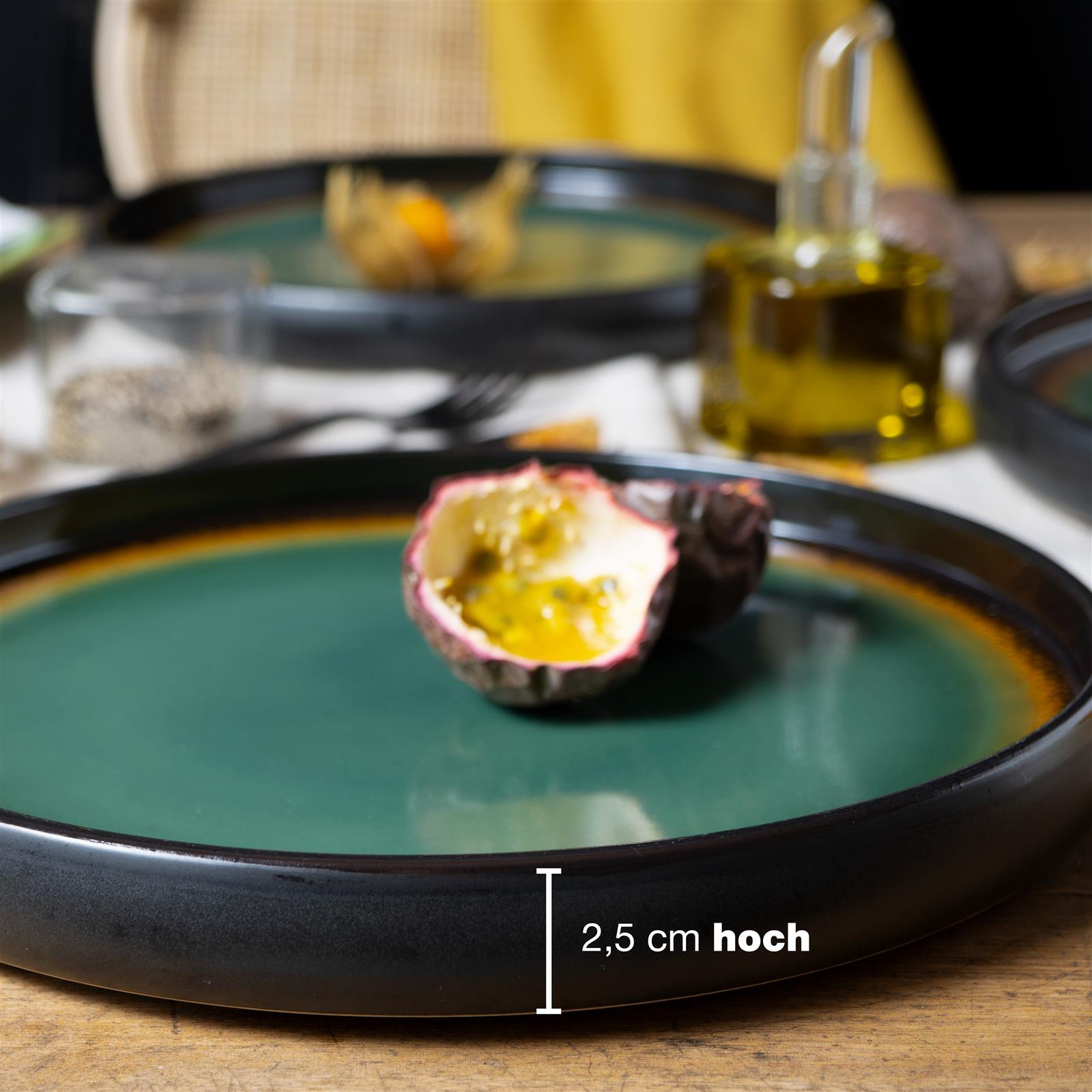 Vier-teiliges Gourmet-Dinner-Teller-Set in reaktivem Grün-Braun, präsentiert auf einer Kulisse. Jeder Teller zeigt