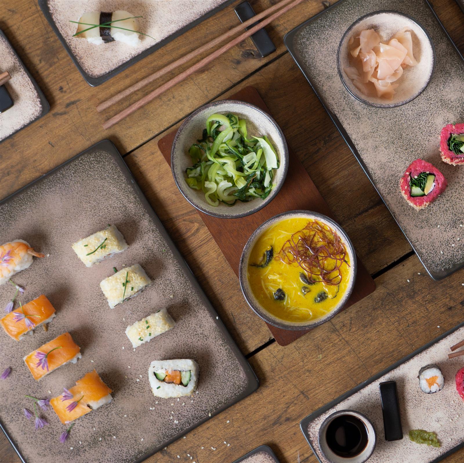 Sushi-Geschirr in Beige, 29-teiliges Sushiset in Beige auf Holzuntergrund, bestehend aus vier rechteckigen Sushi-Tellern