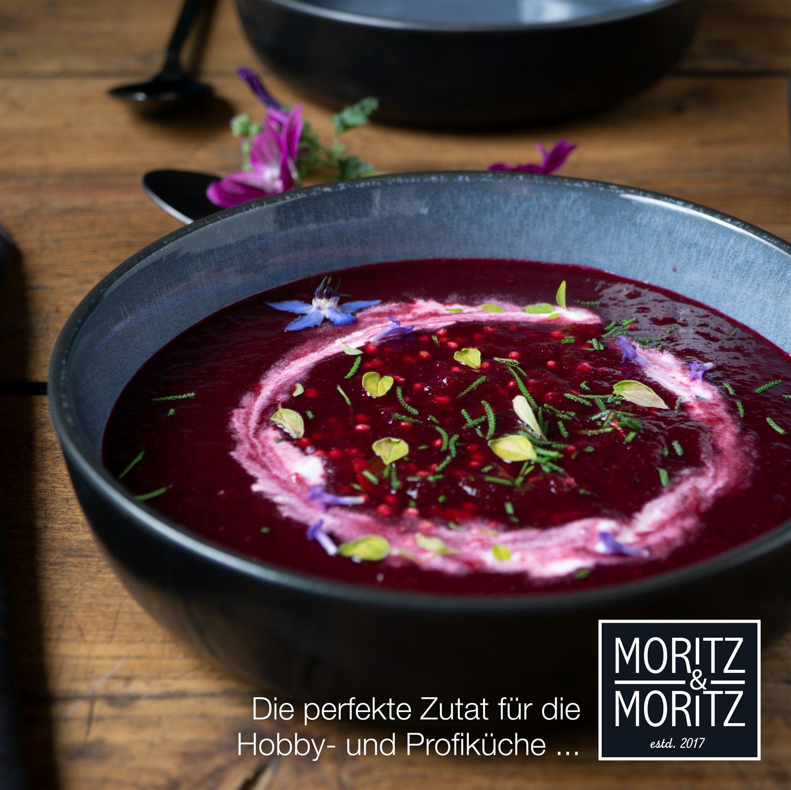 Sechs blaue Gourmet-Suppenteller aus Keramik in Marmoroptik, symmetrisch auf einem gedeckten Holztisch arrangiert