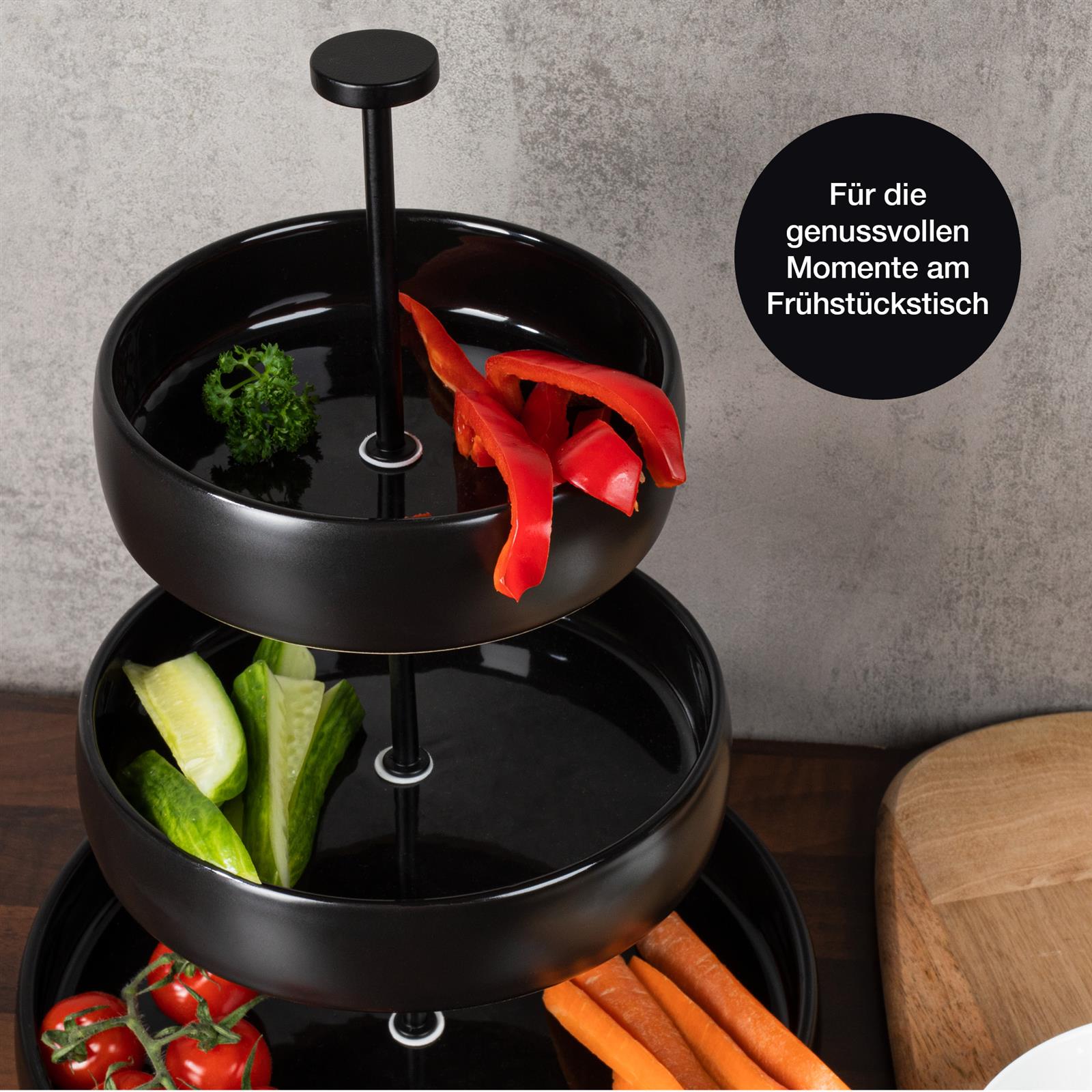 Zweistöckige Etagere aus schwarzem Steingut auf weißem Hintergrund Schwarze runde Etagere aus Steingut mit modernem Design und eleganter Präsentationsfläche für Lebensmittel und Dekorationsartikel.