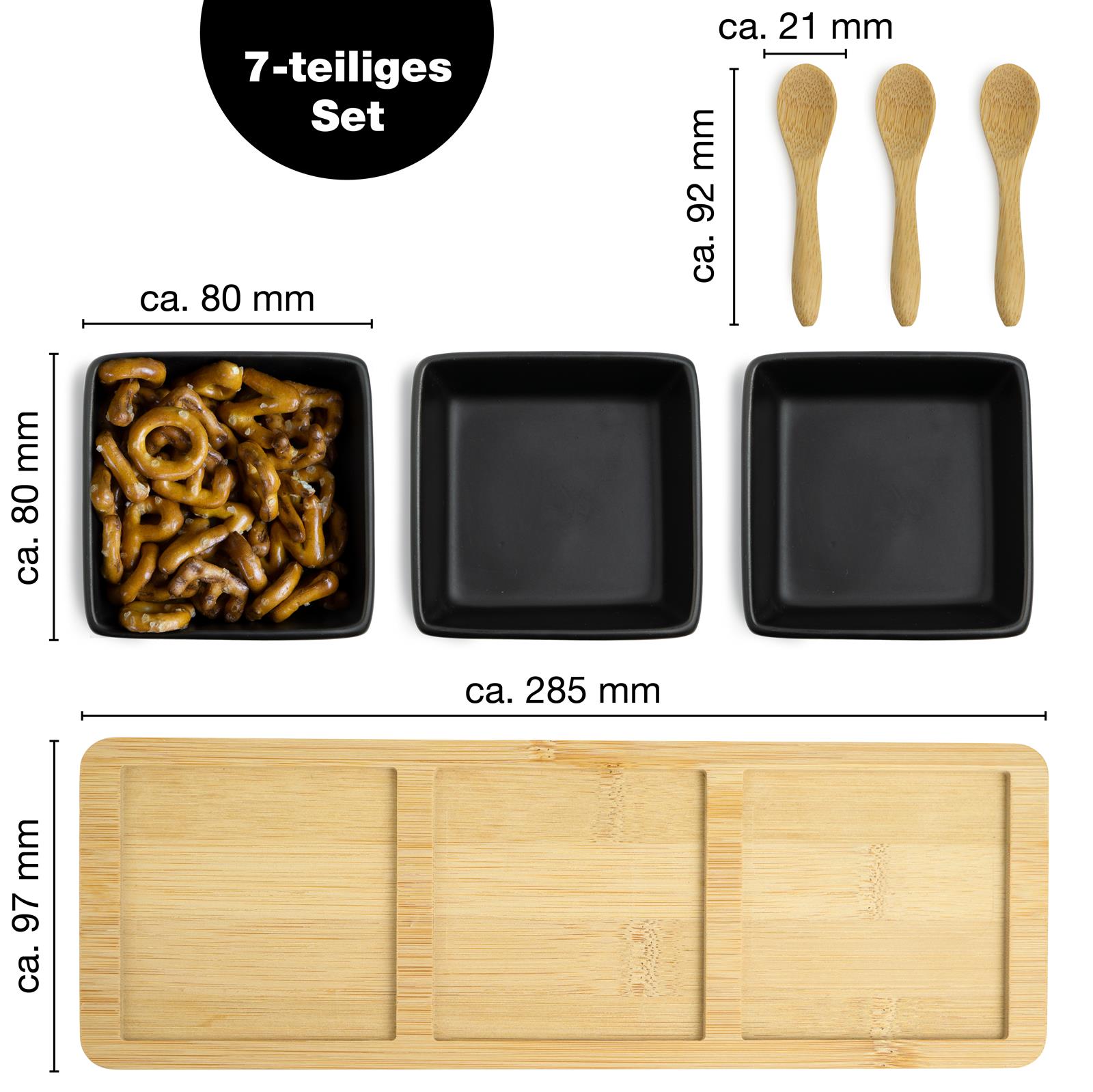 Vier grobe Bratwürste mit sichtbaren Grillstreifen liegen auf einem dunklen Schieferbrett, flankiert von Rosmarinzweigen
