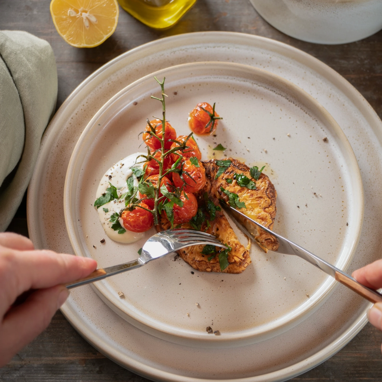 CASTELLO Teller mit Tomaten und Rösti, Besteck in der Hand